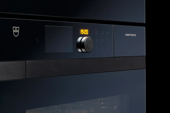 The mirror glass front of the new series with integrated display, central control button and the flush recessed handle, which unfolds on commissioning