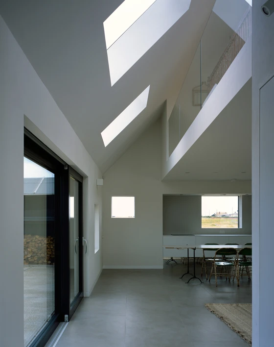 An exposed shingle beach provides the setting for Rodić Davidson Architects' black-stained, larchwood-clad North Vat beach home in Dungeness, England, which is organised across three separate but interconnected cabins. Photos: Hélène Binet