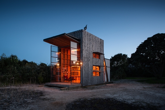 Crosson Architects' timber Hut on Sleds in New Zealand features double-height, glazed steel doors, which open up, dollhouse-like, providing a seamless transition between inside and out. Photos: Simon Devitt