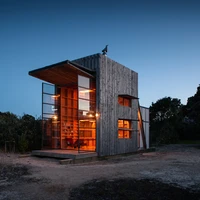 Crosson Architects' timber Hut on Sleds in New Zealand features double-height, glazed steel doors, which open up, dollhouse-like, providing a seamless transition between inside and out. Photos: Simon Devitt
