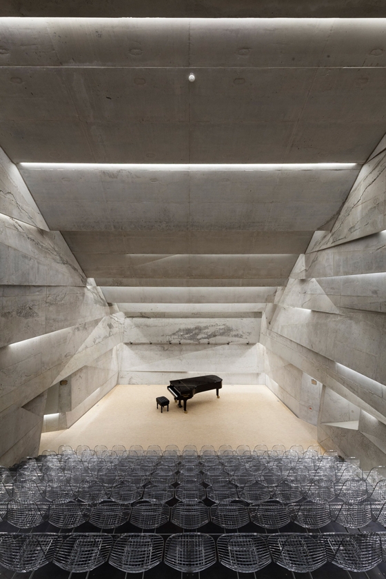 The interior of Peter Haimerl Architektur’s concert hall in the Bavarian village of Blaibach, Germany, with its raked seating, informs the project’s external, upturned form, as if the building has partially subsided; Photos: Edward Beierle