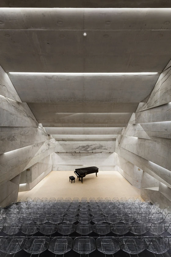 The interior of Peter Haimerl Architektur’s concert hall in the Bavarian village of Blaibach, Germany, with its raked seating, informs the project’s external, upturned form, as if the building has partially subsided; Photos: Edward Beierle
