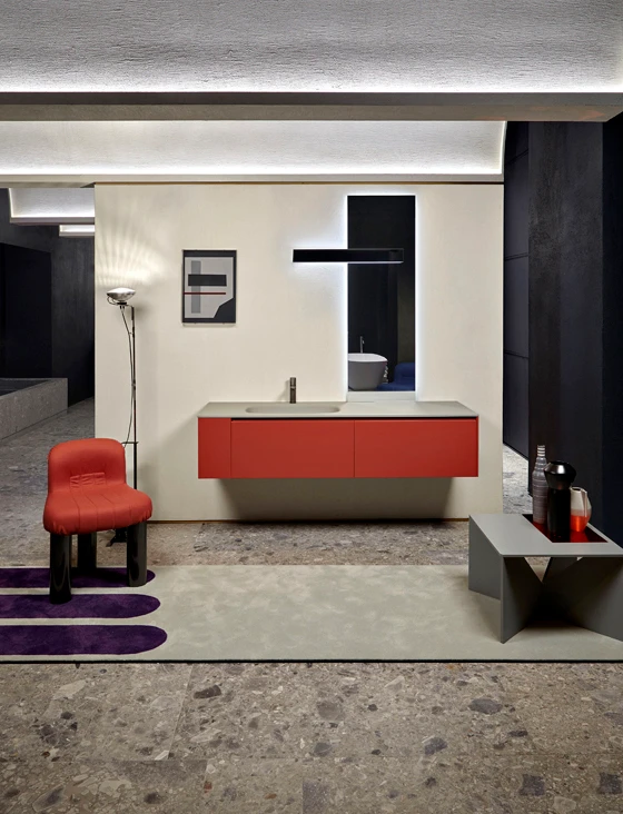 Top: a series of taps are displayed above a monolithic stone sink. Above: wall-mounted vanity units and the Lucente lamp