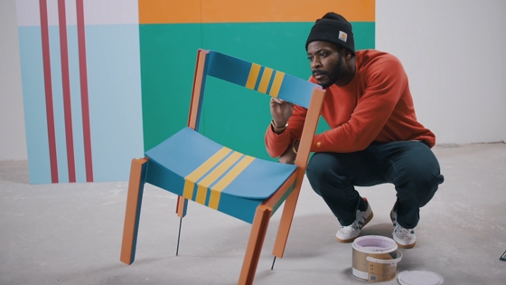 Yinka Ilori with upcycled chair featuring his MiAdidas colour scheme for a WeTransfer collaboration